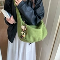 Grand sac hobo en daim vert avec breloque en perles de bois porté par un mannequin - Vert Pomme Avec Pendentif