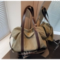 Dettaglio della borsa tote in tela oliva con cinturini in pelle e cerniere dorate - Verde