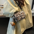 Leopard print crossbody bag with silver chain and a cute teddy bear charm on a beige coat - Khaki Leopard With Charm