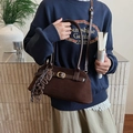 Sac bandoulière marron mat avec breloques rétro et sangle réglable porté par mannequin - Café avec Pendentif