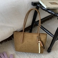 Dettaglio borsa tote in pelle scamosciata marrone con ciondolo di perline boho e manici - Con Ciondolo / Marrone Giallastro