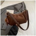 Détail d'un sac porté épaule en daim marron foncé avec pendentif en bois et métal doré - Café avec Pendentif