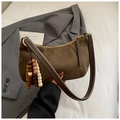 Détail du sac bandoulière en daim marron avec lanière en cuir et breloques en perles - Vert avec Pendentif