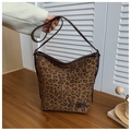 Detail showing the leopard print pattern and brown leather label on the bucket bag - Leopard Print