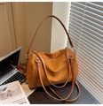 Détail macro du sac oreiller en daim marron avec ses bandoulières en cuir - Marron