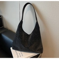 Close-up of black laser-cut geometric patterns on a vintage leather hobo shoulder bag - Black