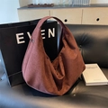 Brown-red suede hobo tote bag with matte finish on a minimalist black sofa setting - Red Brown