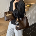 Dark brown oil wax leather tote bag with matching pouch and bunny charm on a model - Brown