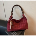Detail of burgundy suede tote bag featuring quilted texture and wooden bead accents - Burgundy
