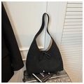 Detail of black suede crescent bag with drawstring bow on a silver suitcase - Black