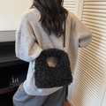 Faux shearling tote bag in black featuring a circular handle and leather shoulder strap - Black