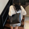 Classic black leather tote bag with polka dot scarf detail on a model in vintage setting - Black