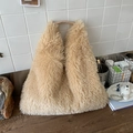 Faux fur beige tote bag with brown leather handles in a cozy home setting - Khaki