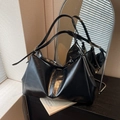 Minimalist black leather tote bag with soft folds and slim straps in a lifestyle setting - Black