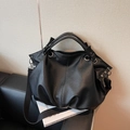 Bolso tote de piel lichi negra con ojales plateados y correa de hombro ancha - Negro
