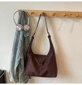 Dark brown suede hobo bag with adjustable strap in a casual lifestyle setting - Brown