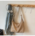 Brown suede hobo tote bag with metal logo, shown hanging with casual accessories - Khaki