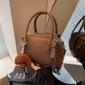 Bolso Boston de cuero marrón con correa ajustable y colgante de perro de peluche - Café con Colgante