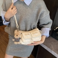 Cream white crossbody bag with bow details and teddy bear charm on model - White with Pendant