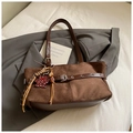 Close-up of brown suede tote with metal buckle detail and leopard bear charm - Coffee with Pendant