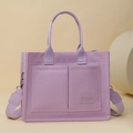 Dettaglio della borsa tote in tela viola con tasche frontali e tracolla larga regolabile - Viola