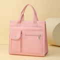 Detalle de bolso tote de lona rosa con bolsillo frontal y textura de tela duradera - Rosa
