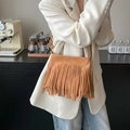 Bohemian brown suede crossbody bucket bag with long tassels shown on a model - Matte Khaki