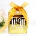 Macro shot of laser-cut birdcage candy box with golden texture and orange ribbon - Reflective Gold