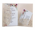 Macro view of laser-cut floral lace wedding invitation with champagne gold finish - Nude Pink