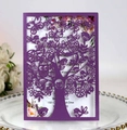 Macro view of purple laser-cut invitation featuring intricate tree, bird, and butterfly patterns - Dark Purple