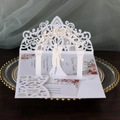 Elegante 3D-Hochzeitseinladung mit Laserschnitt-Motiv Brautpaar unter einem Blumenbogen - Weiß