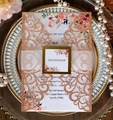 Dettaglio dell'invito di nozze tagliato al laser in oro rosa con carta floreale e fascia - Oro Champagne Scintillante