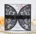 Détail macro de l'invitation noire découpée au laser avec ruban et motif floral - Noir