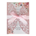 Detail showing pink laser-cut glitter wedding invitation with a satin bow and floral print - Glitter Pink