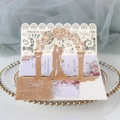 Macro detail of 3D pop-up wedding invitation featuring laser-cut floral patterns and gold glitter - Glitter Rose Gold