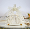 Elegant white laser-cut peacock wedding candy box with ribbon on a decorative gold plate - Ivory