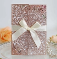 Makro-Detail der Laser-Hochzeitseinladung mit Glitzer-Finish und Satinbandschleife - Glitzer Champagnergold