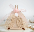 Detail of laser-cut peacock pattern gift box with pink organza ribbon on a white plate - Champagne