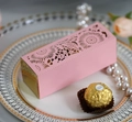 Dettaglio della scatola nuziale rosa e oro tagliata al laser con motivi floreali su un piatto - Rosa