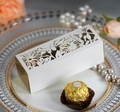 Detail of white laser-cut favor box with golden lining and floral pattern cutout - Ivory