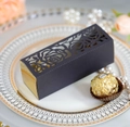 Macro view of laser-cut rose patterns on elegant black and gold gift packaging boxes - Black