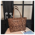 Close-up of leopard print tote bag with brown leather handles and silver brand logo - Leopard Brown