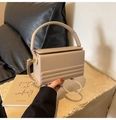Vista detallada del bolso caja beige con textura de cuero suave y diseño estructurado - Color Té con Leche
