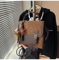 Detail view of leopard print backpack with brown leather star charm and cute bear plush - Brown with Pendant