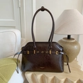 Détail d'un sac cabas en cuir ciré marron avec boucles en métal doré sur table en pierre - Brun Sans Pendentif