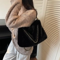 Borsa tote nera in peluche con catena dorata indossata da modella per l'autunno - Nero
