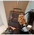 Detail of vintage brown leather backpack with gold star buckles and plush bear charm - With Charm / Brown