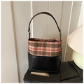 Vue détaillée du tissu à carreaux vintage et des finitions en cuir noir du sac seau - Vert