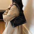 Black leopard print tote bag with bow detail worn by a model in a beige trench coat - Black