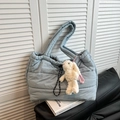 Quilted light blue puffer tote bag with a plush rabbit charm on a stylish leather sofa - Haze Blue With Charm